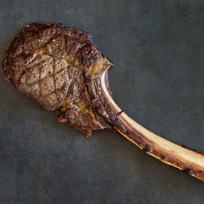 Tomahawk steak raw meat on dark background for premium meat category