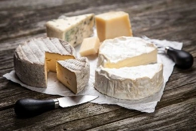 Assorted artisan cheese blocks and wedges on wooden table