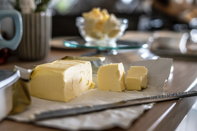Premium yellow butter blocks on parchment paper with a butter knife
