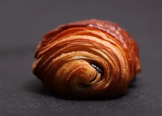Freshly baked pain au chocolat French pastry on a dark surface